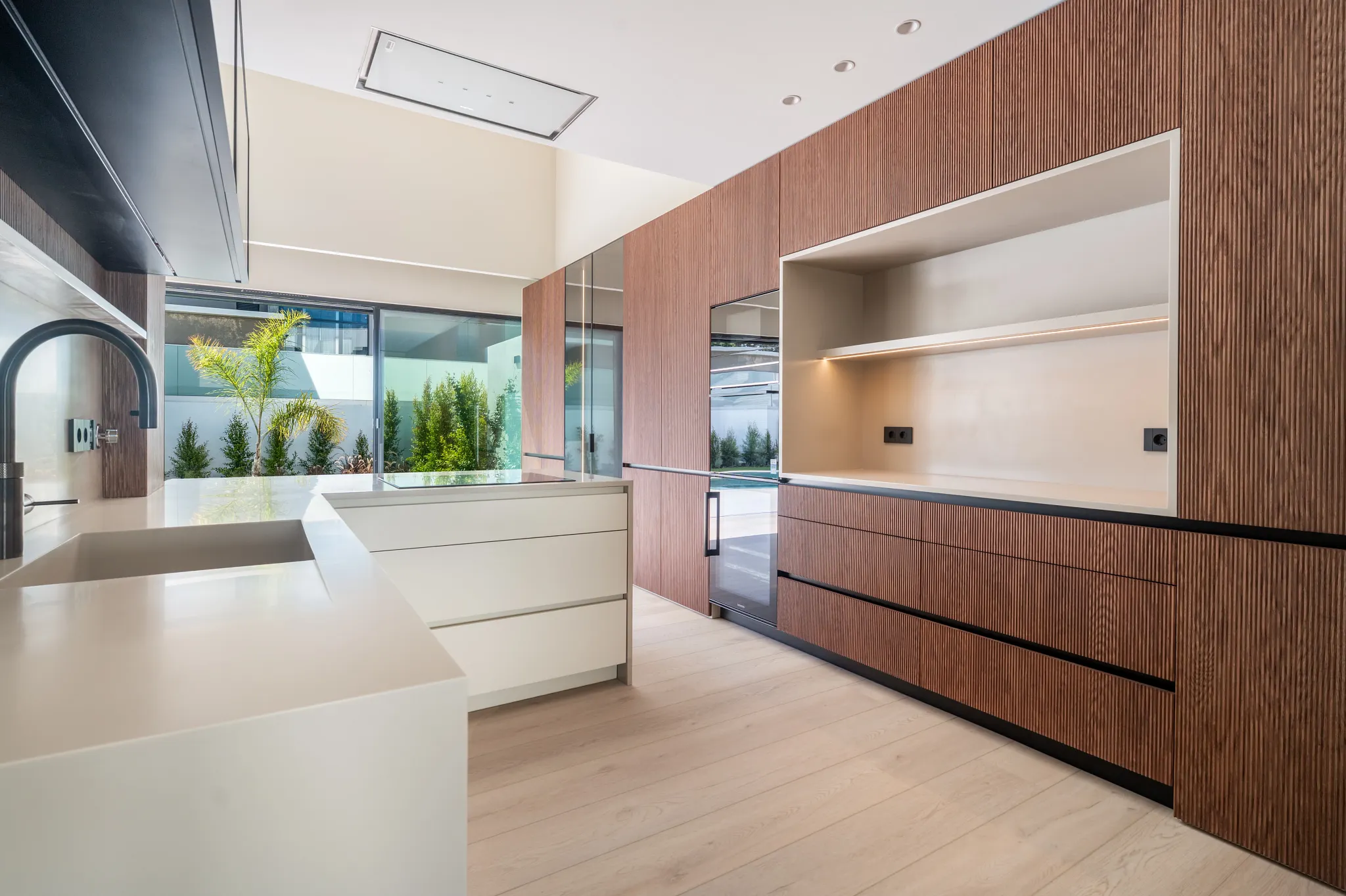 Modern kitchen with walnut cabinets and wooden floors from Coretec