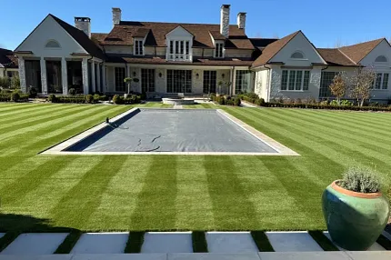 Luxury home exterior with pristine landscaping Elegant house with manicured lawn and pool area