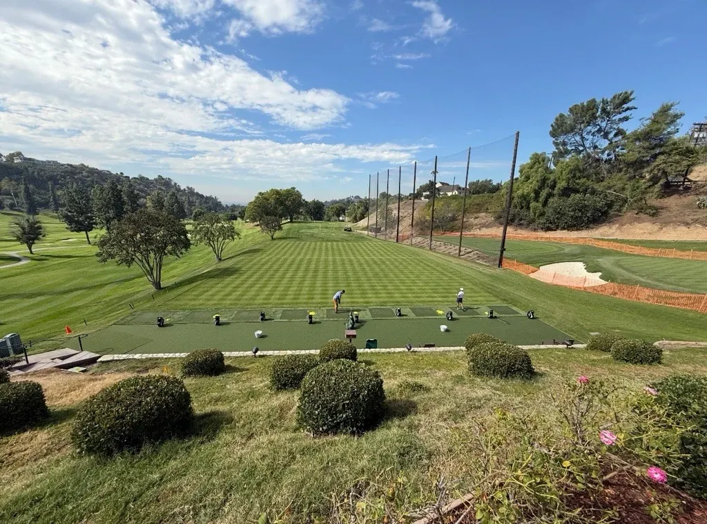 Scenic view of a golf course with players practicing