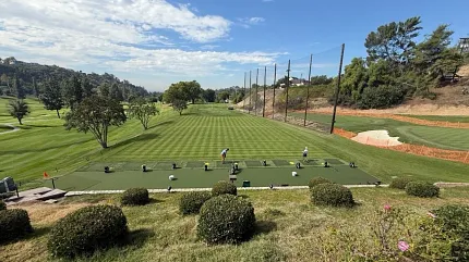 Picturesque golf course landscape with practice area Scenic view of a golf course with players practicing