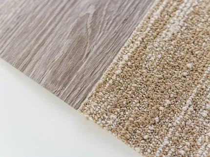 Light Brown Vinyl and Beige Carpet Tile Flooring Swatch Close-up of a flooring swatch featuring a light brown wood-look vinyl and a beige textured carpet tile