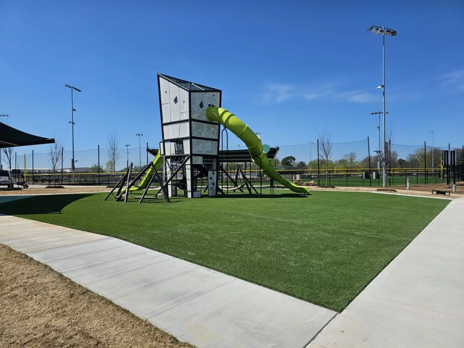 Playground with green slide and artificial turf