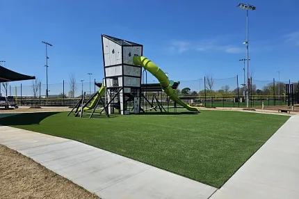 Modern playground with durable artificial grass surface Playground with green slide and artificial turf
