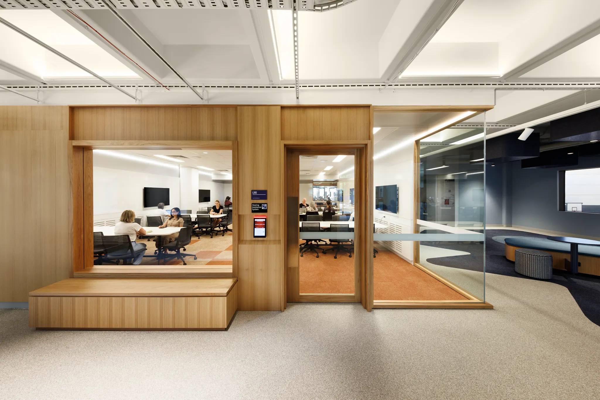 Modern higher education space with wood paneling and carpet flooring