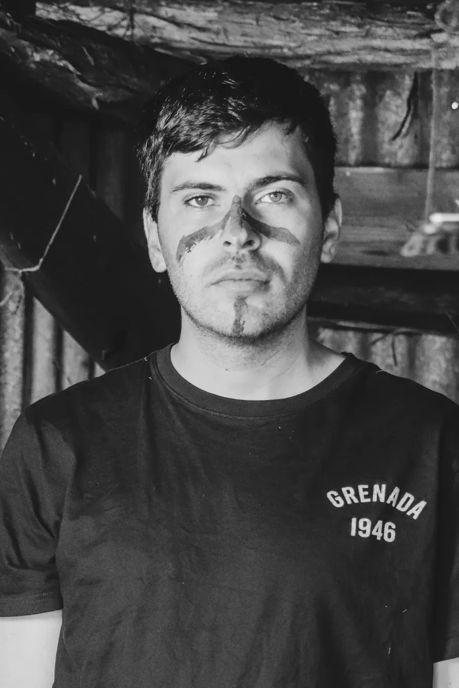 Black and white image of a man with paint on his face