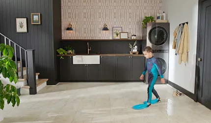 Stylish beige tile flooring for contemporary laundry spaces Modern laundry room with beige tile flooring and dark cabinetry