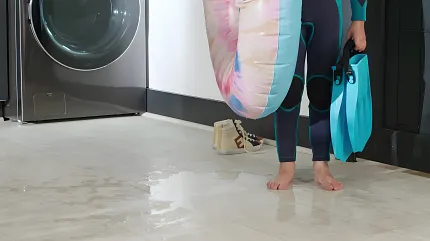 Durable waterproof luxury vinyl flooring in modern laundry room scene Waterproof luxury vinyl flooring in a laundry room with a person holding a surfboard and flippers