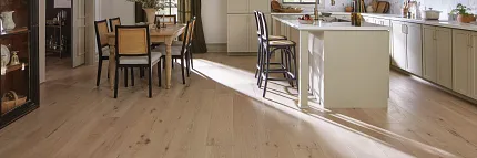 Light Hardwood Flooring in a Contemporary Kitchen and Dining Space Modern kitchen and dining area with light hardwood flooring, featuring a cozy and practical design with natural light