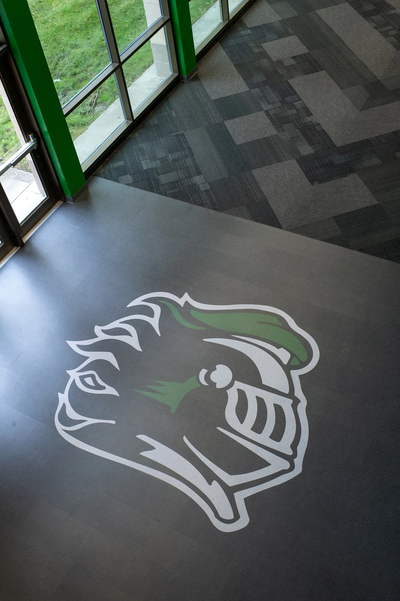 Heavy commercial luxury vinyl tile flooring with custom logo in an education facility