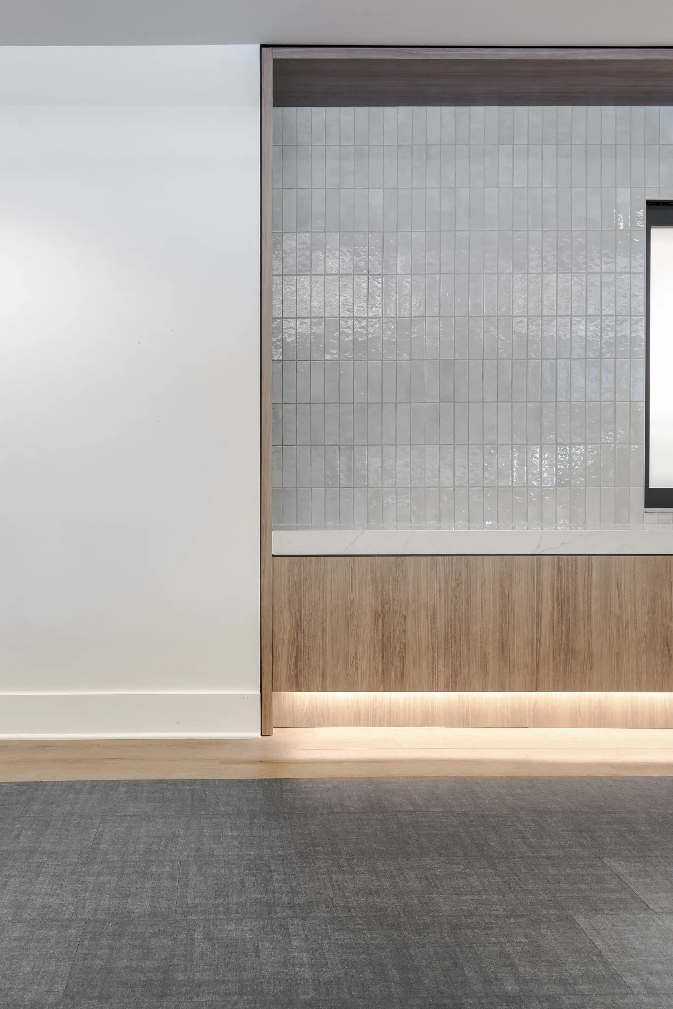 Modern education facility interior with gray commercial carpet tile and light wood paneling