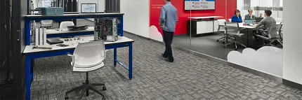 Commercial Carpet Tile in Modern Workplace Setting Modern workplace with commercial carpet tile flooring, featuring a collaborative meeting room and workstations