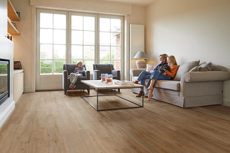 A family sitting in a living room with Coretec vinyl flooring visible.