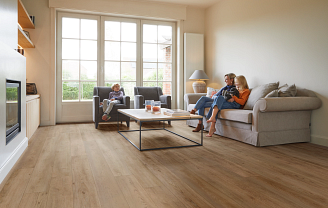 A family sitting in a living room with Coretec vinyl flooring visible.