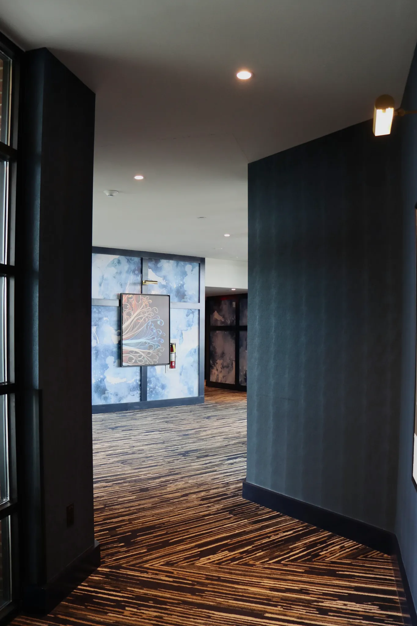Modern hallway with abstract art and striped carpet flooring