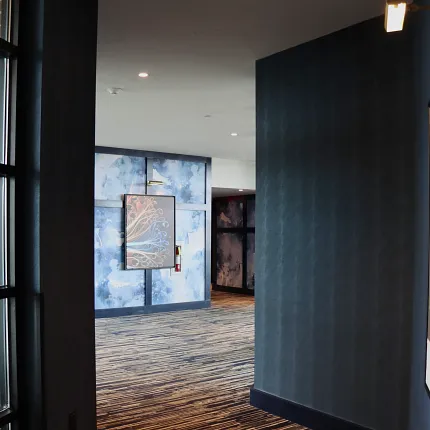 Stylish commercial carpet for contemporary hospitality spaces Modern hallway with abstract art and striped carpet flooring