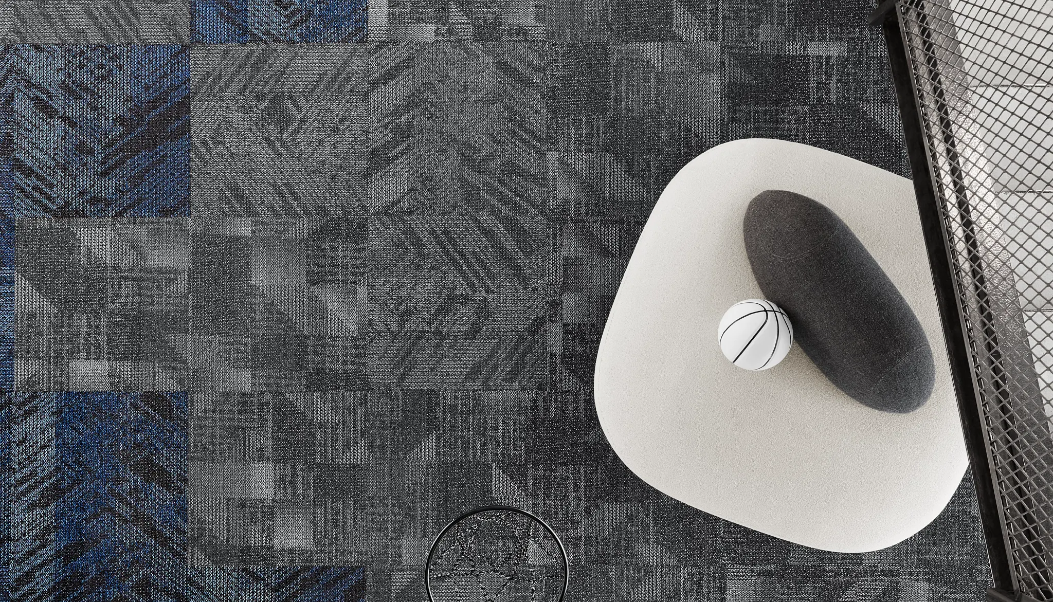 Overhead view of a modern education facility with grey and blue commercial carpet tile flooring, featuring geometric patterns and a basketball hoop