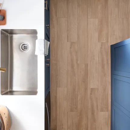 Contemporary kitchen design with light brown wood-look flooring and stainless steel sink Modern kitchen with stainless steel sink and light brown wood-look flooring
