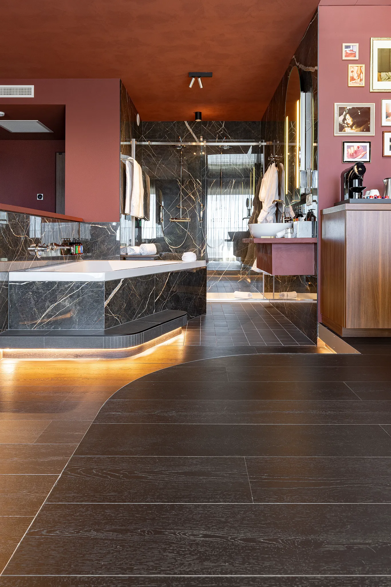 Dark and moody hotel room with connecting bathroom and black wooden Coretec floors