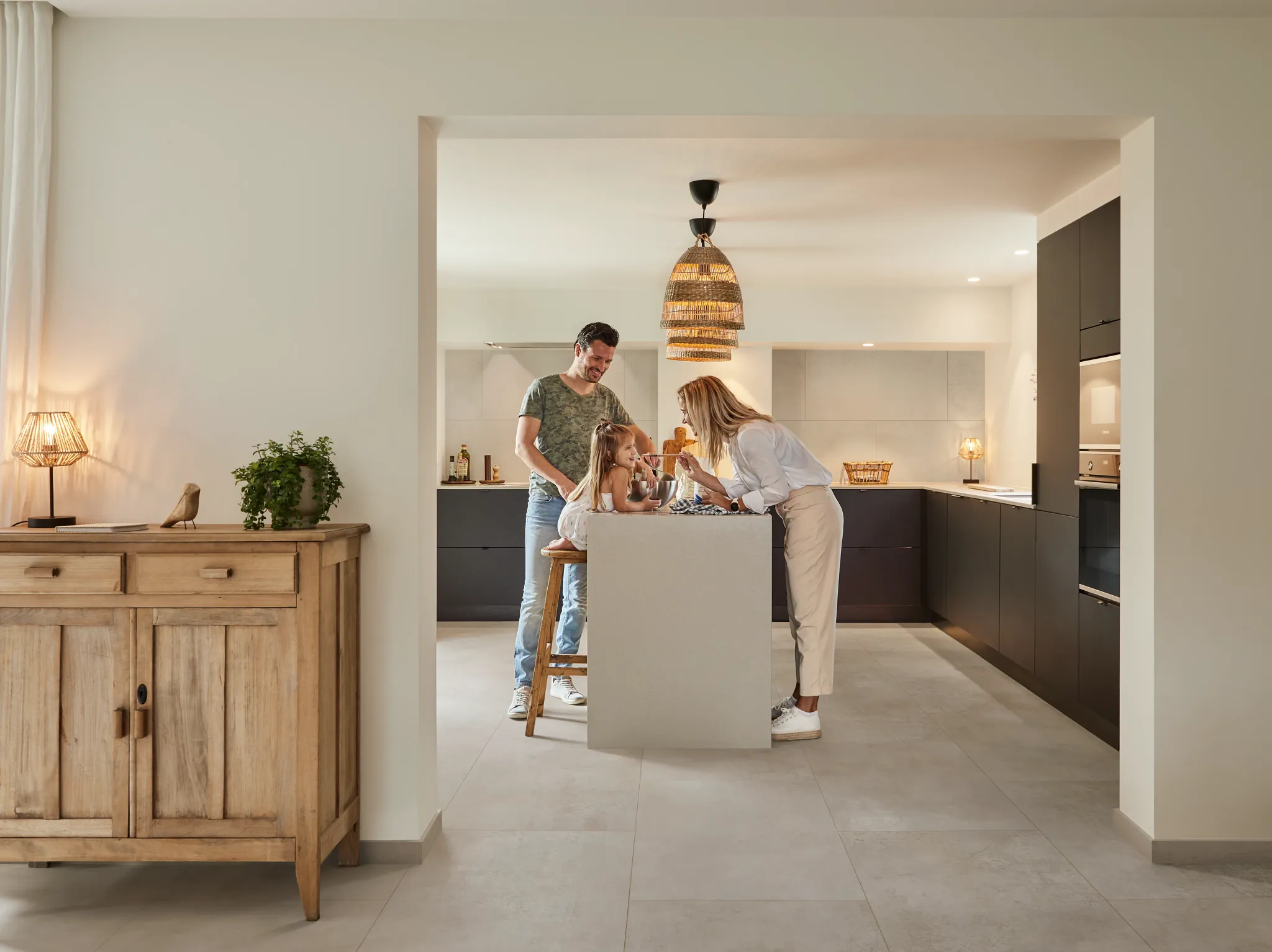 kitchen with family enjoying time together with stone look luxury vinyl tile floor and  dark cabinetry
