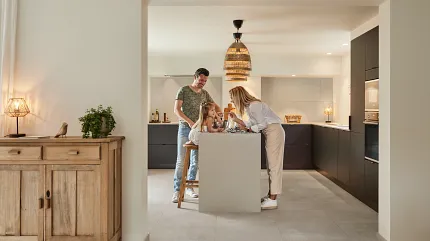 Stone Look Luxury Vinyl Tile Flooring in Modern Family Kitchen kitchen with family enjoying time together with stone look luxury vinyl tile floor and dark cabinetry