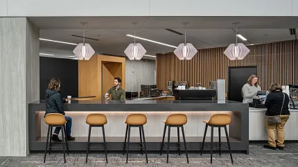Contemporary Workplace Lounge with Commercial Carpet Tile Flooring Modern workplace lounge area with commercial carpet tile flooring, featuring a bar counter with stools and pendant lighting