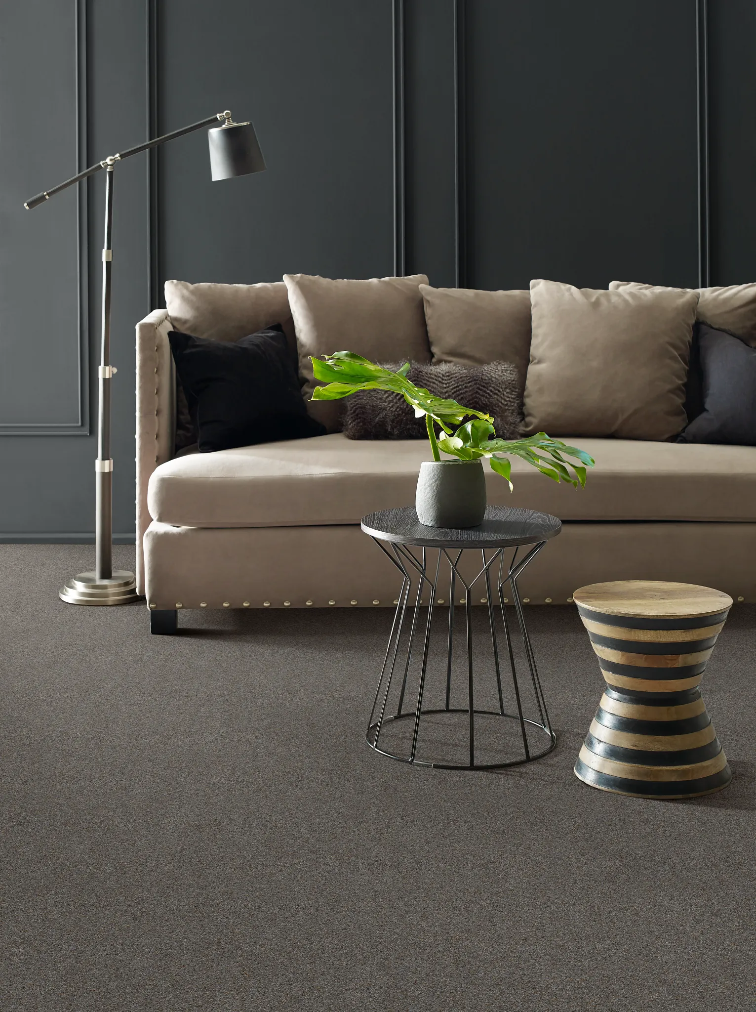 Modern living room with beige sofa, black and beige pillows, metal floor lamp, and soft surface flooring from Shaw Floors