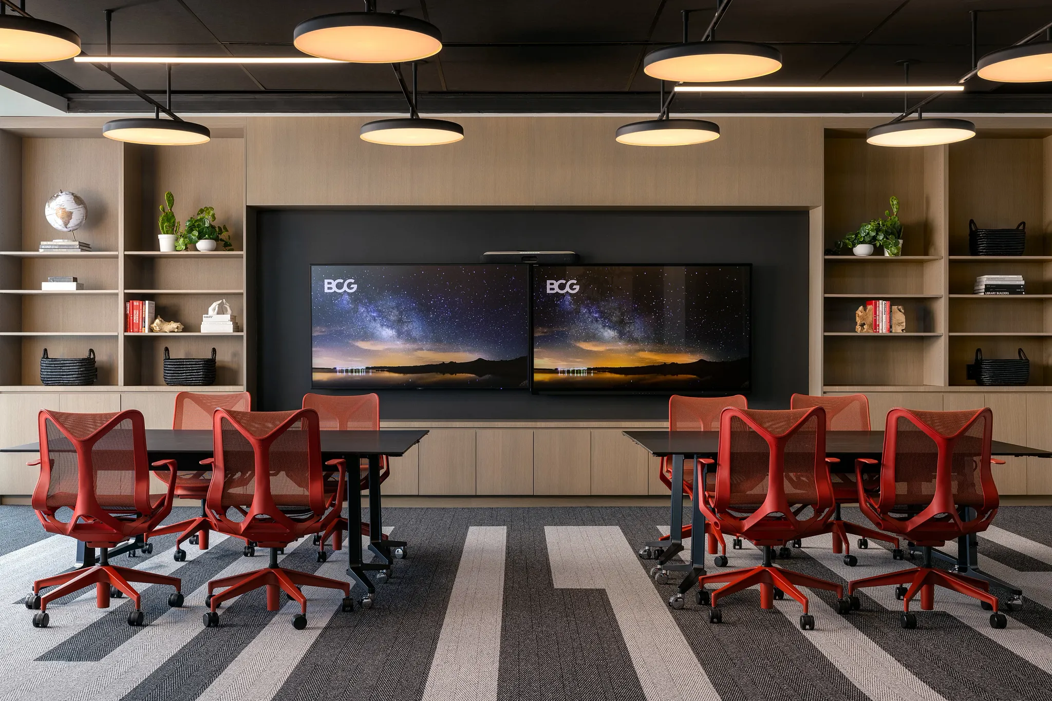 Modern workplace conference room with red chairs and striped commercial carpet tile flooring
