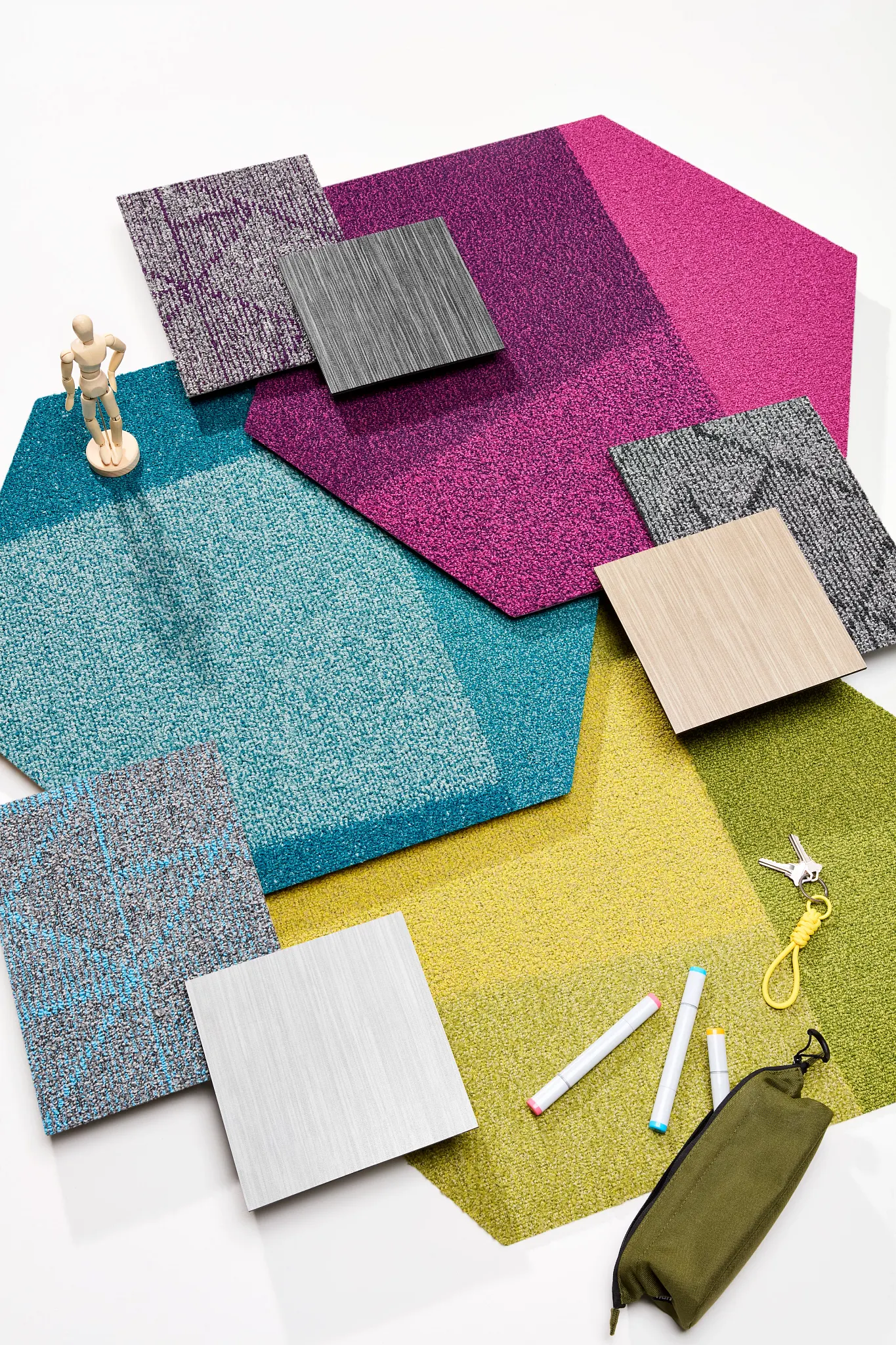 Assorted commercial carpet tile samples in vibrant colors including pink, teal, yellow, and gray